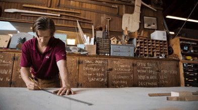 Young man measuring in a workshop