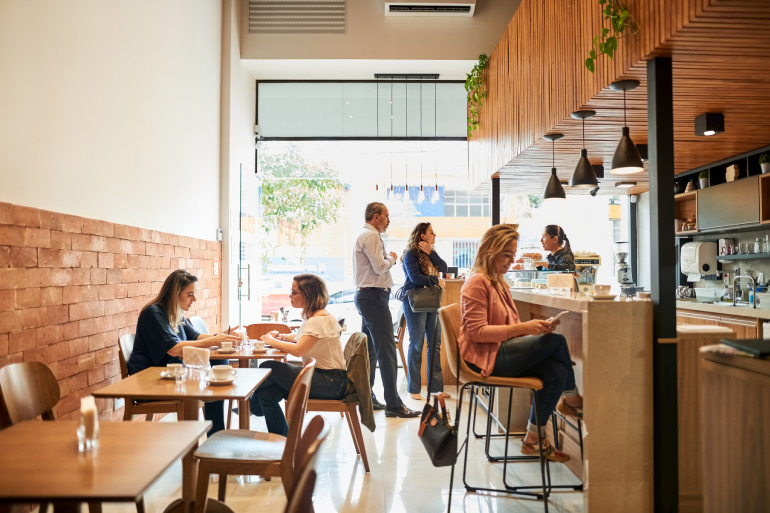 Customers sitting inside of a cafe.
